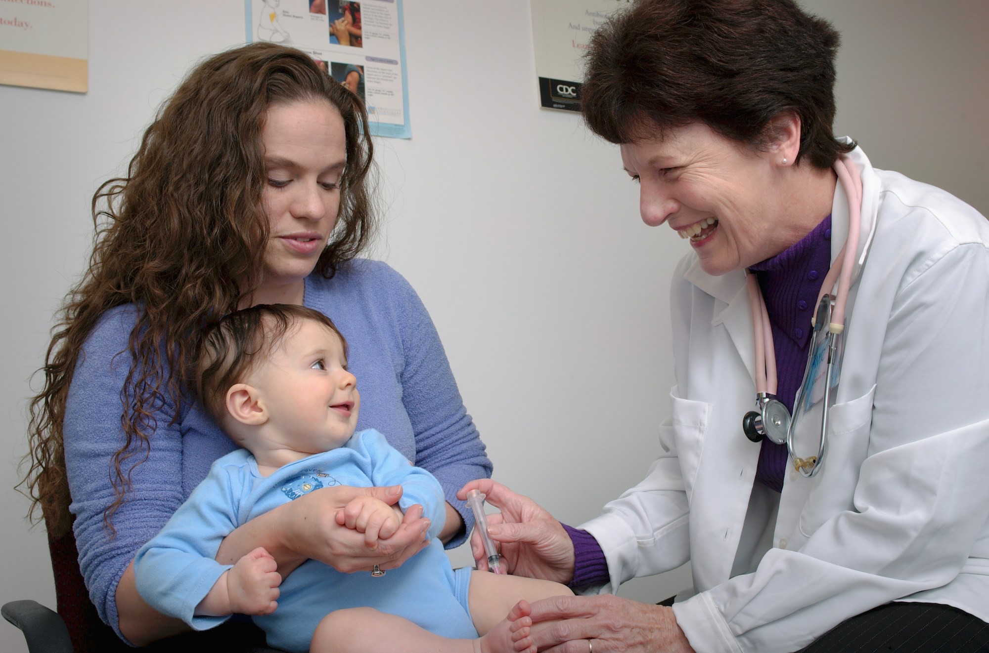 A doctor examining a baby with a parent